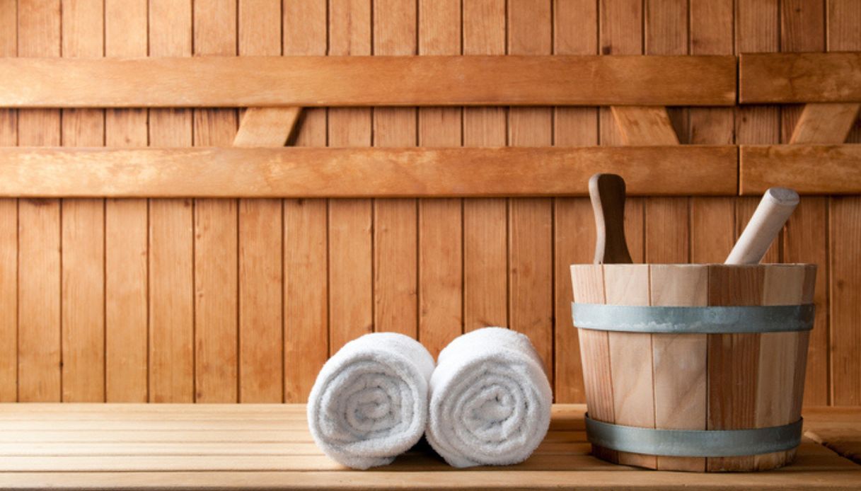 Secchio di legno e asciugamani all'interno di una sauna nelle terme dell'Alto Adige